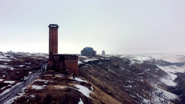 Iconic aerial view of the historic Mosque of Minuchihr, the first Turkish mosque in Anatolia, standing on the edge of the snowy Akhurian River gorge in Ani