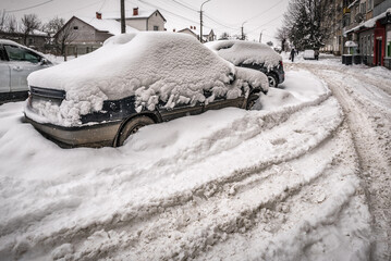 Cars stucked in deep snow on the street after snowstorm