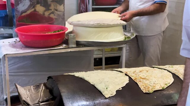 Kurdistan bread bakery in Iran local flat culinary culture baked baking crispy thin saj metal griddle dough flour yeast kalaneh stuffed scallion herbs spring folded butter ghee crunchy crust delicious