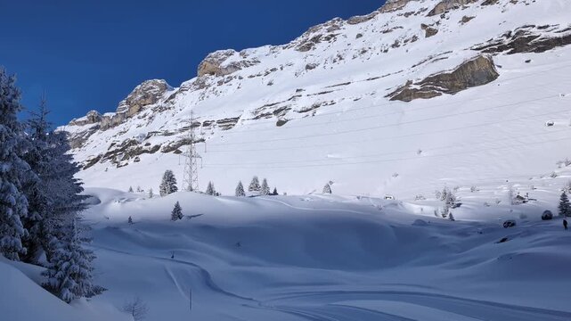 People walking and snowshoeing on a mountain pass in the winter, Sunnbuel to Gemmi Pass