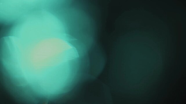 Light leak and bokeh overlay with teal and green hues, creating a dreamy, ethereal mood. Perfect for adding artistic effects to your videos.