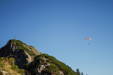 Paraglider around a summit cross, Germany

