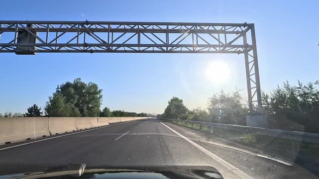 Driving on D1 highway in western Slovakia with low sun glare and clear blue sky