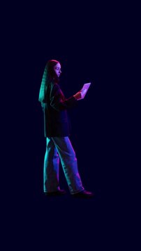 Loop animation. Young professionals illuminated by blue and red neon light isolated on dark background. Concept of tech recruitment campaign, digital talent search and modern startup hiring.
