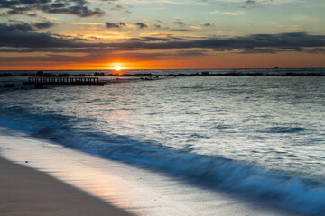 Obraz premium Amazing colourful sunrise seen over the Mediterranean Sea from Barceloneta Beach, which is located next to Barcelona's classic fishing quarter. It is the cities oldest and best-loved beach and gives w