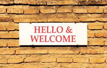 Fototapeta premium Hello and welcome symbol. Concept words Hello and welcome on beautiful big white sign plate. Beautiful old brown brick wall background. Business hello and welcome concept. Copy space.