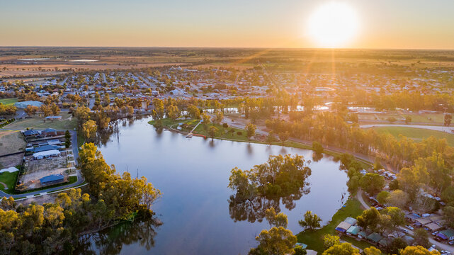 Aerial view of sunset over a country town lining a wide curving river