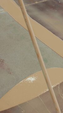 Construction worker spreading epoxy resin on concrete floor