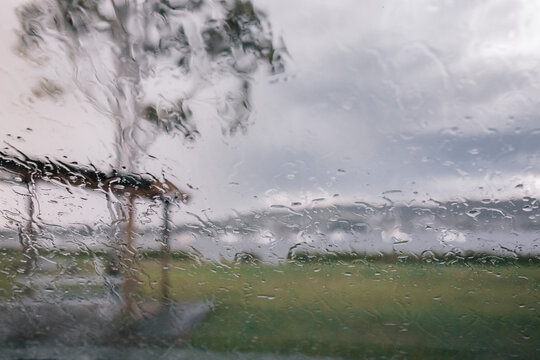 Heavy rain on car windscreen overlooking lake