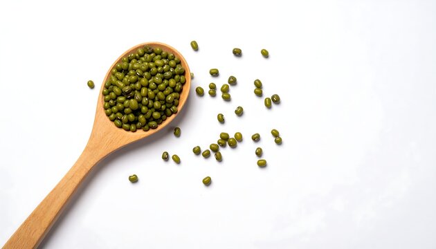 Wooden spoon filled with small green mung beans, scattered on white