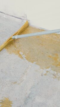 Worker applying epoxy resin on concrete floor