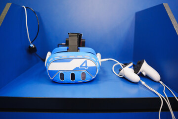 Virtual reality headset and controllers on blue shelf in gaming area
