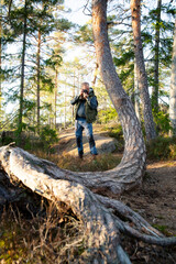 Obraz premium Travel content creator scouting forest location and using vintage camera for authentic storytelling. Adventure travel, Eco-mindfulness and outdoor lifestyle concept.