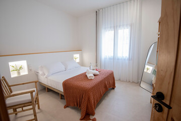 Modern bedroom interior with white walls and comfortable bed