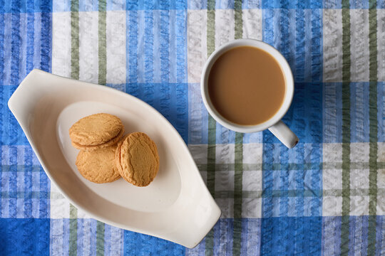 overhead view of Monte Carlo biscuits with coffee cup on blue tablecloth