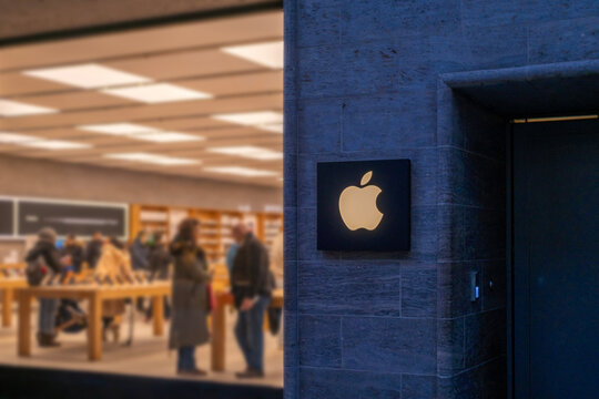 Apple logo on dark, retail store with customers, premium tech brand, urban electronics destination, Sales Office, electronics brand, blurred interior retail space, storefront Hannover, Germany
