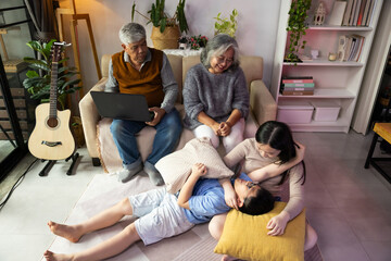 Obraz premium teasing. sisters and brothers are having fun teasing each other. Asian sibling having fun playing game. Happy Family leisure activity with parents and children playing video game living room at home