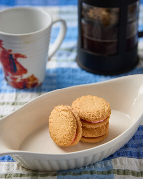 Monte Carlo biscuits on dish with cup and plunger behind.
