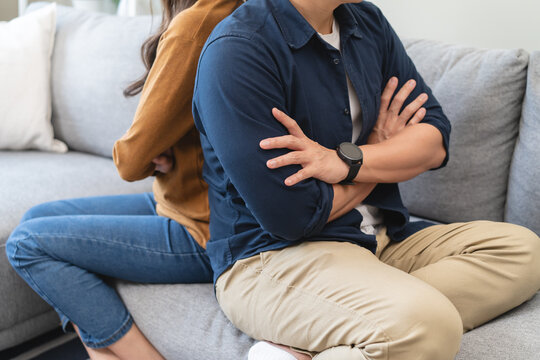 Family problem concept, Asian wife and husband sitting back to back in the living room at home have problems in a relationship and have an argument