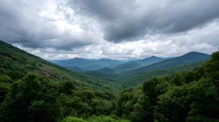 Layered green mountains stretch into the distance under a dramatic cloudy sky highlighting natural beauty and vast wilderness