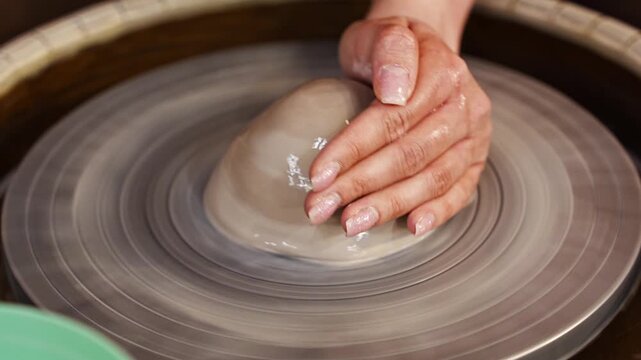 Working with clay on a potter's wheel in a studio setting
