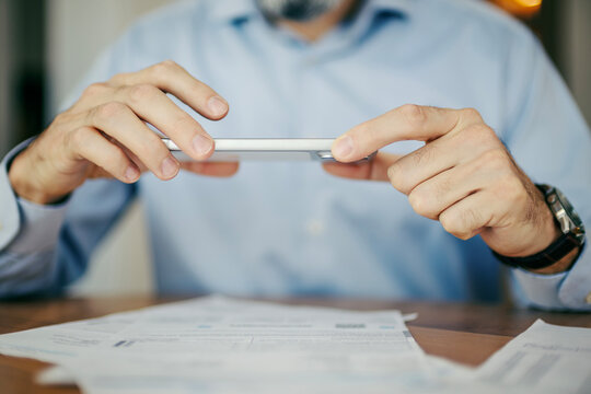Person using smartphone for mobile banking depositing check