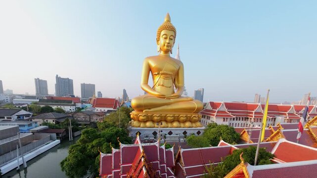 Cinematic FPV drone fly around giant golden Buddha at Wat Paknam temple in Bangkok, Thailand. Aerial movement over city skyline and Buddhist landmark.