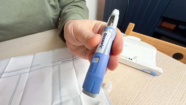 A Caucasian male hand holds a semaglutide injection pen, resembling a futuristic quill, evoking World Diabetes Day solemnity; Ozempic, GLP 1, Semaglutide, January 5 2026, Subotica, Serbia