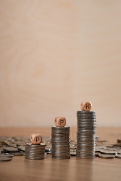 Stacks of Polish coin stacks with PPK letter blocks symbolizing pension saving, employee benefit and retirement contribution in Poland, with copy space for text.