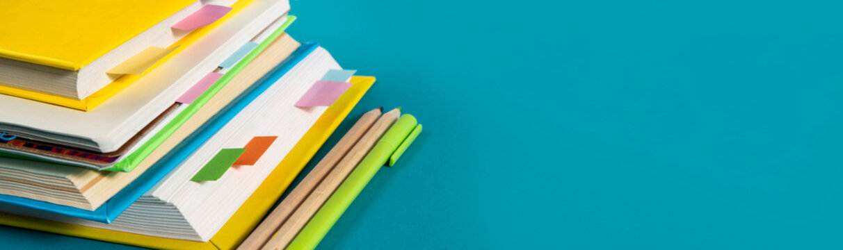 Notepad, notebooks, textbooks and books with bookmarks and stickers. The concept of diligent study