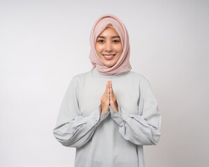 Portrait happy young asian muslim woman standing greeting pose on isolated white background. Islamic Attractive Muslim man wearing islam costume and praying © Chanakon