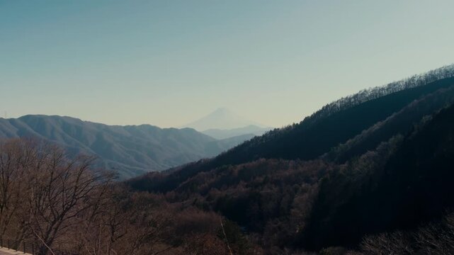 Serene landscape composition with Fuji framed by natural ridges.