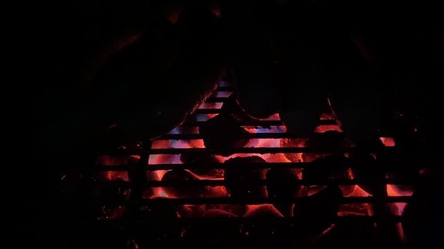 Gl&uuml;hende Holzkohle im Grill mit roter Glut und Funken. Stimmungsvolles BBQ-Feuer &ndash; Hitze, Rauch und romantische Lagerfeuer-Atmosph&auml;re, ideal als Video-Hintergrund.