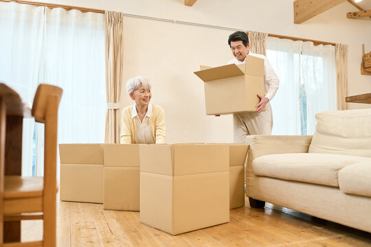 荷物をまとめるアジア人シニア夫婦