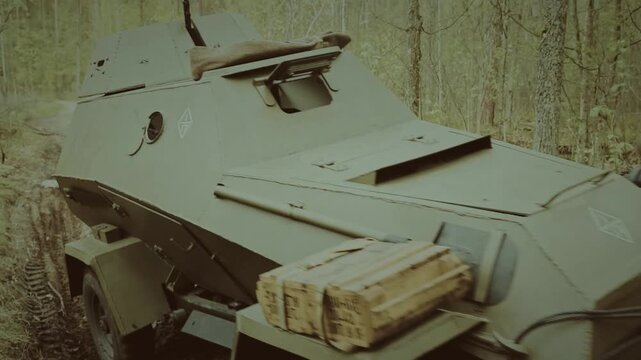Vintage Soviet light armored car driving on a forest dirt road