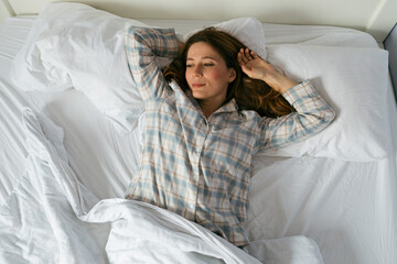 Woman Relaxing in Bed After Waking Up in Soft Morning Light