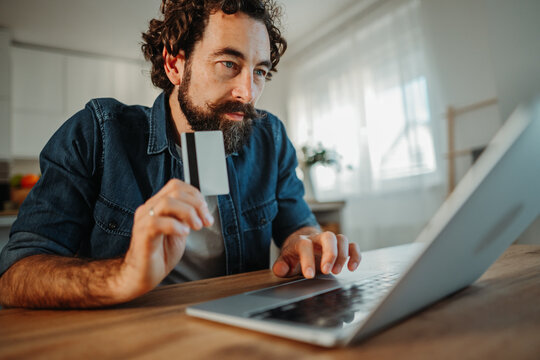 Man making an online purchase using credit card and laptop