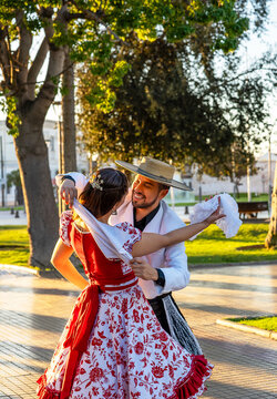 Couple dancing cueca in traditional costume, celebrating chilean culture