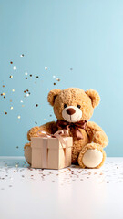 Teddyb&auml;r mit Geschenk vor blauem Hintergrund