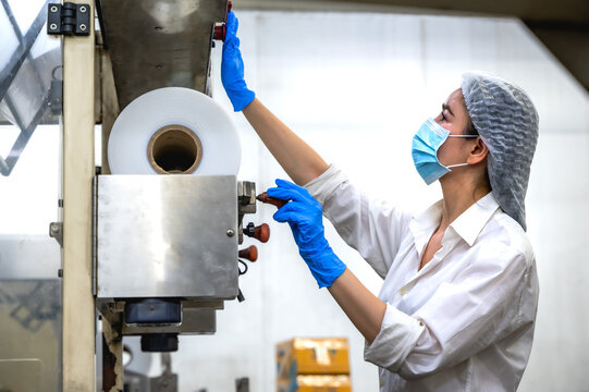 Female Asian food factory worker working on plastic packing in export frozen food manufacturing