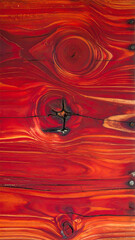 Rote Holzstruktur mit Astloch als Hintergrund