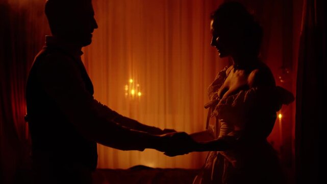 Black silhouette two gothic person, happy couple dancing together man king holding hand sexy noble woman queen. Night dark room candles light. Adult girl guy old style, love medieval ball themed party