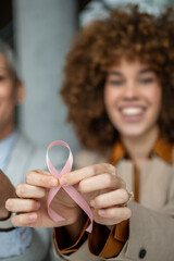 Woman holding pink ribbon supporting breast cancer awareness
