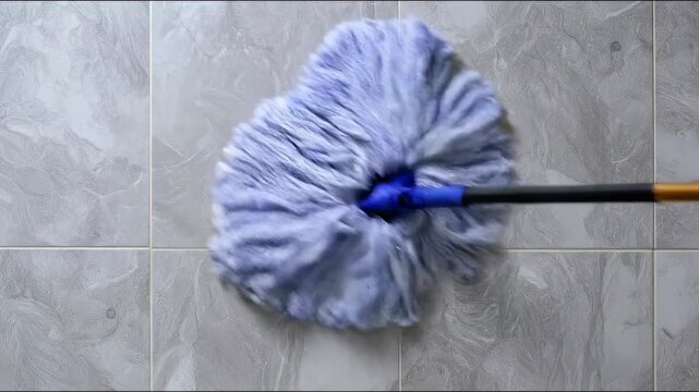 Close-up view of a microfiber mop cleaning a tiled floor, showcasing texture and cleaning action