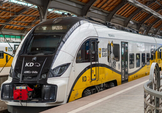 Modern PESA Elf 2 train of Koleje Dolnośląskie (KD) at Wrocław Gł&oacute;wny station, service to Brzeg &ndash; Polish regional rail transport, white and yellow 48WEc electric multiple unit at platform.