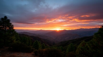 Obraz premium Vibrant sunset over dramatic mountain range with colorful clouds and sun rays