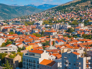 Obraz premium High angle view of Mostar town in Bosnia and Herzegovina. Sunny day scene featuring traditional architecture, residential houses, and green hills. Travel and tourism concept in the Balkans