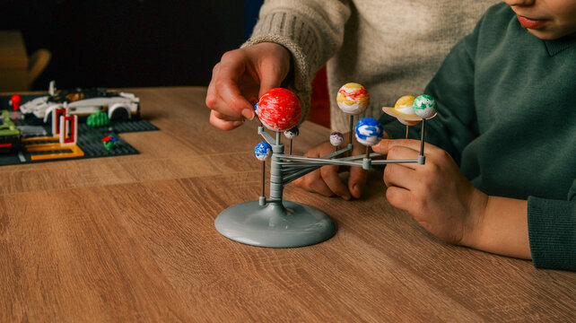 Children learning about the solar system with a model planetarium and educational toys