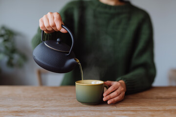 Pouring warm tea in a cozy setting during a peaceful afternoon