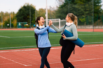 Obraz premium Friends giving high five enjoying outdoor fitness workout